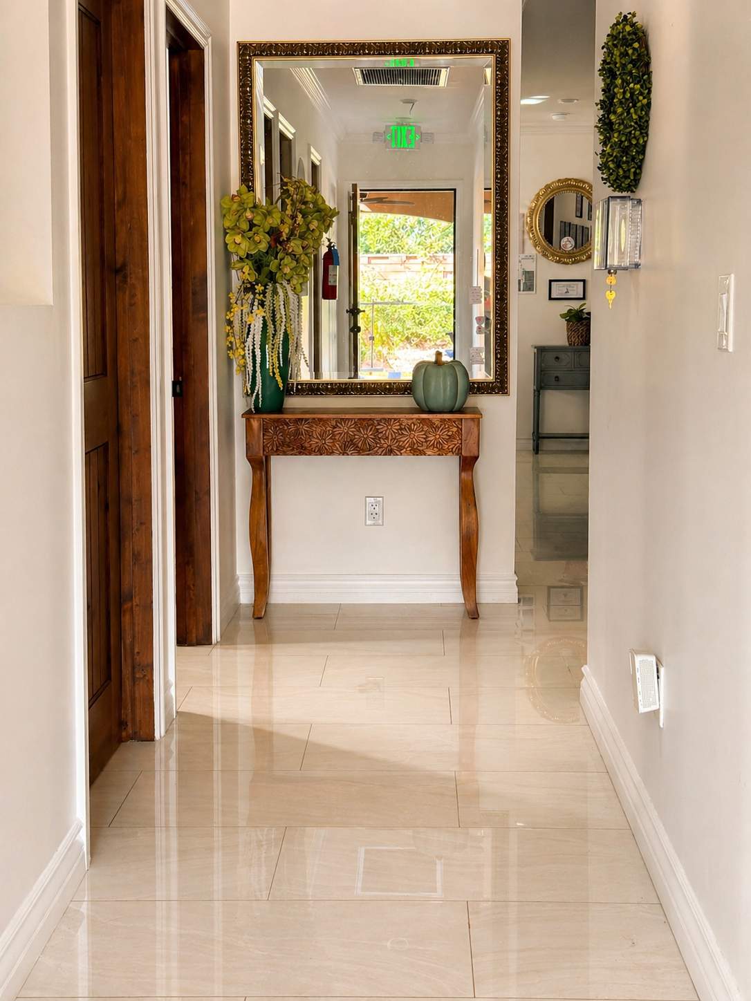 Bright entry hallway with mirror, console table, and polished floors