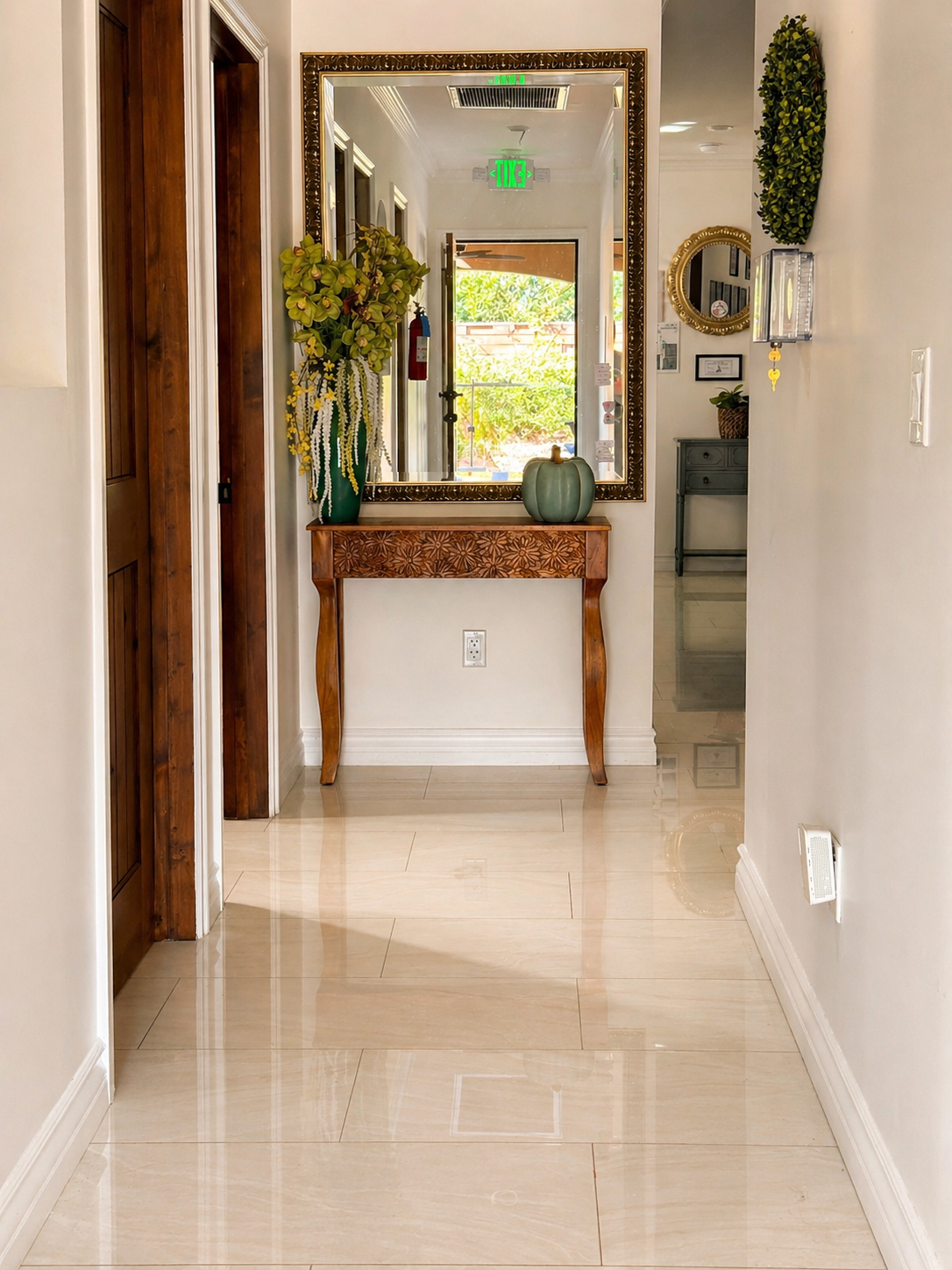 Bright entry hallway with mirror, console table, and polished floors