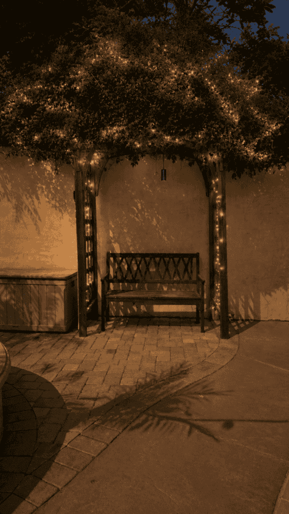 Pergola bench with string lighting in the evening