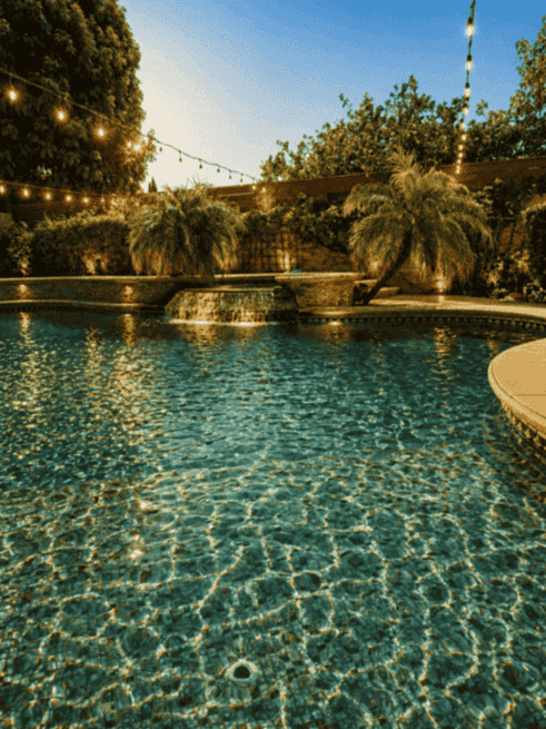 Wide view of the backyard pool at twilight