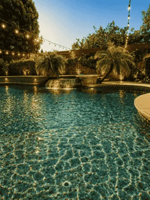 Wide view of the backyard pool at twilight