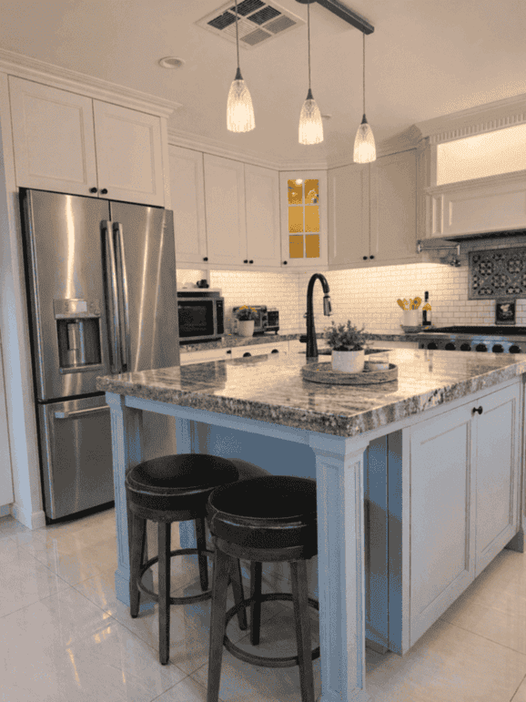 Kitchen with granite island, pendant lights, and stainless appliances