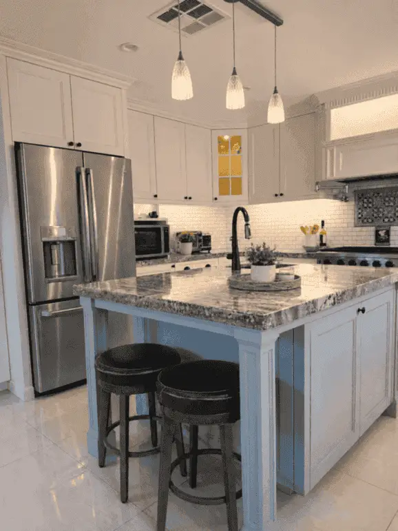 Kitchen with granite island, pendant lights, and stainless appliances